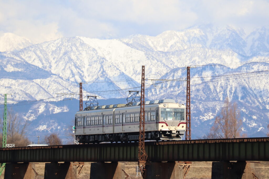 立山連峰をバックに走る富山地方鉄道